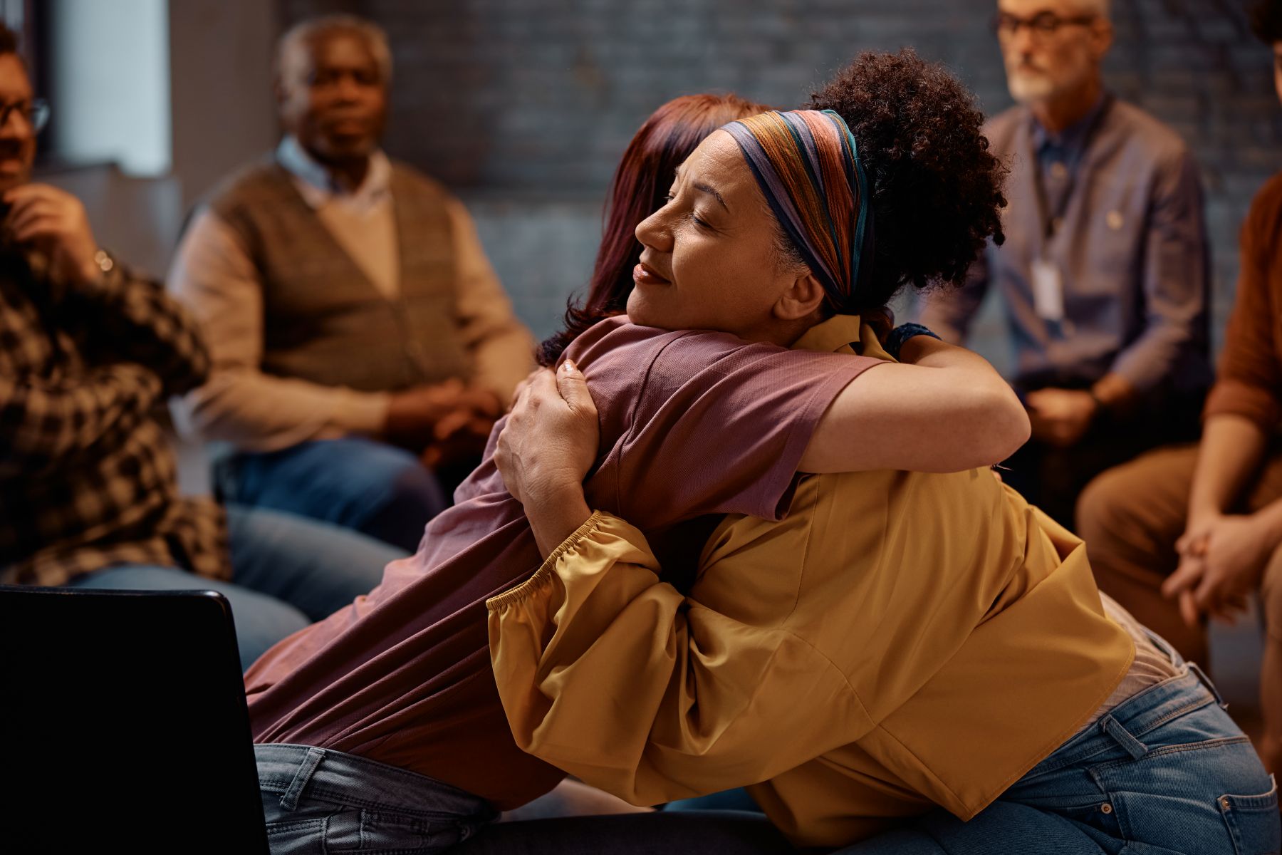 Two women hugging each other during mental health support group