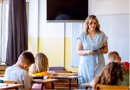 Teacher leading a classroom of elementary school students.